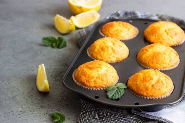 Ev yapımı limonlu kek üzerinde yemek pişirme siyah teflon içinde beton arka plan gri. Kopya alanı.