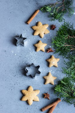 Geleneksel Noel gingerbread çerezleri ve ardıç şube ile Noel dekor gri beton zemin üzerine. Metin için yer kopyalayın.