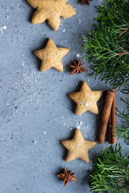 Geleneksel Noel gingerbread çerezleri ve ardıç şube ile Noel dekor gri beton zemin üzerine. Metin için yer kopyalayın.