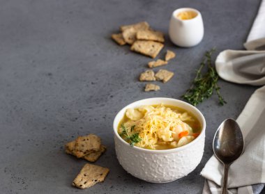 İtalyan çorbası Sebzeli Makarna ve beyaz fasulye ile çorba iki beyaz kase taze kekik ile tepesinde ve kraker gri beton zemin üzerine hizmet verdi. Vejetaryen yiyecekler kavramı.