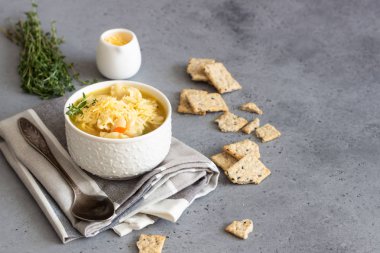 İtalyan çorbası Sebzeli Makarna ve beyaz fasulye ile çorba iki beyaz kase taze kekik ile tepesinde ve kraker gri beton zemin üzerine hizmet verdi. Vejetaryen yiyecekler kavramı.