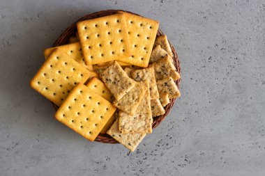 Tohum ve otlar gri beton zemin üzerine ince çıtır tuzlu kraker. 