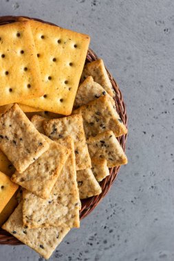 Tohum ve otlar gri beton zemin üzerine ince çıtır tuzlu kraker. 