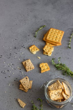 Tohum ve otlar gri beton zemin üzerine ince çıtır tuzlu kraker. 