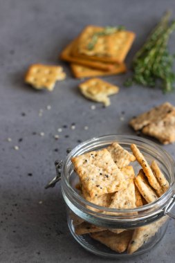 Tohum ve otlar gri beton zemin üzerine ince çıtır tuzlu kraker. 