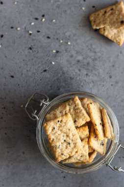 Tohum ve otlar gri beton zemin üzerine ince çıtır tuzlu kraker. 