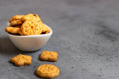 Gri beton zemin üzerine tatlı mini kurabiyeler. Metin için boş alan.