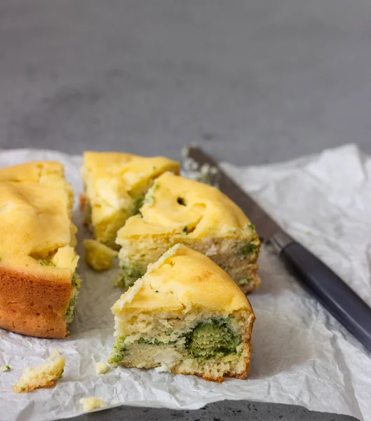 Corn cake with broccoli on parchment paper.