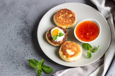 Süzme peynir krep veya reçel, Doğal yoğurt veya ekşi krema ve nane ile börek. Geleneksel Rus mutfağı. Syrniki. Sağlıklı ve diyet kahvaltı.