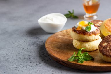 Krep peynir veya lor börek dekore edilmiş tatlım, ekşi krema ve nane. Sağlıklı ve diyet kahvaltı.