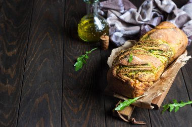 Ev yapımı örgülü roka pesto ekmek. İtalyan ekmeği. Eski ahşap arka plan. Kopya alanı. 