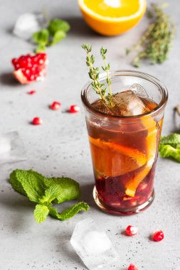 Soğuk limonata veya nar, nane ve turuncu ile şenlikli kokteyl. Gri beton arka plan. Kopya alanı.