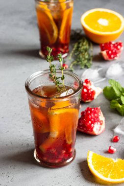 Soğuk limonata veya nar, nane ve turuncu ile şenlikli kokteyl. Gri beton arka plan. Kopya alanı.