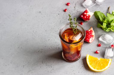 Soğuk limonata veya nar, nane ve turuncu ile şenlikli kokteyl. Gri beton arka plan. Kopya alanı.