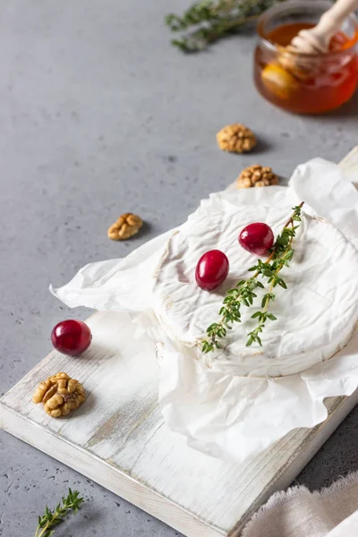 Camembert Mit Preiselbeeren Walnüssen Honig Und Thymian Auf Pergamentpapier Gebacken — Stockfoto