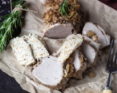 Soğan, sarımsak ve biberiye ile fındık ezmesi kahverengi taş masada servis ile domuz eti kızartma. 