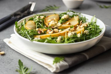 Roka, gorgonzola peyniri, Karamelize armut ve fındık salata. Sağlıklı gıda. Hafif kahvaltı, öğle veya akşam yemeği. 