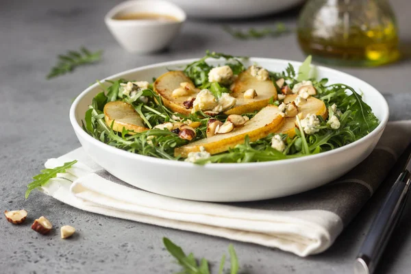 Arugula, gorgonzola cheese, caramelized pear and nut salad. Healthy food. Light breakfast, lunch or dinner.