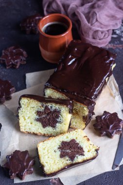 Vanilyalı sade kek çikolata sır ile kahverengi kağıt üzerinde çikolata bisküvi yıldız ile devam eder. Kahverengi taş tablo. Kopya alanı.