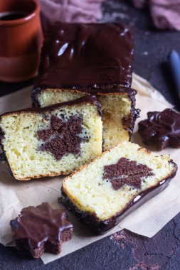 Vanilyalı sade kek çikolata sır ile kahverengi kağıt üzerinde çikolata bisküvi yıldız ile devam eder. Kahverengi taş tablo. Kopya alanı.