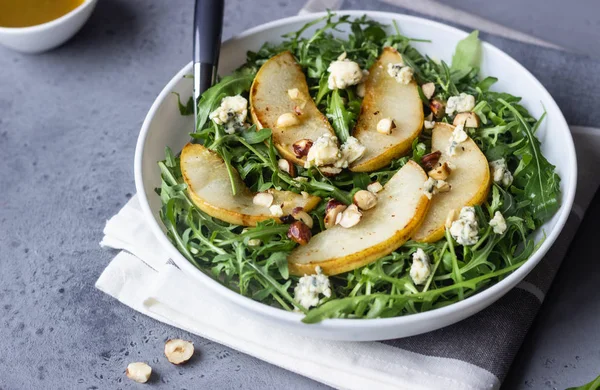 Arugula, gorgonzola cheese, caramelized pear and nut salad. Healthy food. Light breakfast, lunch or dinner.