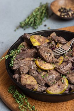 Elma, soğan ve kekik bir tavada kızarmış tavuk karaciğer. 