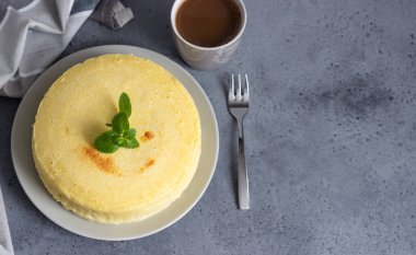 Gri bir plaka üzerinde nane ile Japon pamuk cheesecake. Kabuk peynirli kek. Gri taş veya beton arka plan. Seçici odak, kopya alanı. 