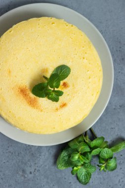 Gri bir plaka üzerinde nane ile Japon pamuk cheesecake. Kabuk peynirli kek. Gri taş veya beton arka plan. Seçici odak, kopya alanı. 