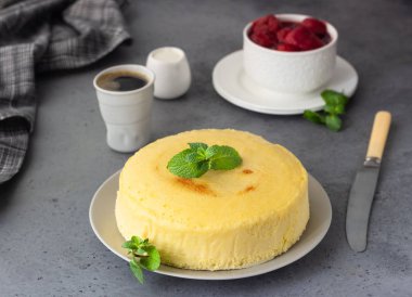 Gri bir plaka üzerinde nane ile Japon pamuk cheesecake. Kabuk peynirli kek. Gri taş veya beton arka plan. Seçici odak, kopya alanı. 