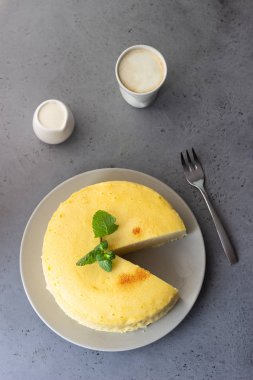 Gri bir plaka üzerinde nane ile Japon pamuk cheesecake. Kabuk peynirli kek. Gri taş veya beton arka plan. Seçici odak, kopya alanı. 