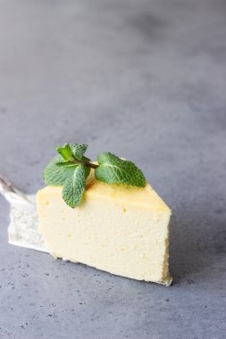Japon pamuk cheesecake nane ile bir parça. Kabuk peynirli kek. Gri taş veya beton arka plan. Seçici odak, kopya alanı. 