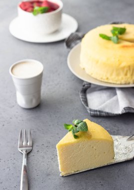 Japon pamuk cheesecake nane ile bir parça. Kabuk peynirli kek. Gri taş veya beton arka plan. Seçici odak, kopya alanı. 
