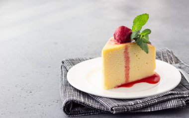 Japon pamuk cheesecake nane ve çilek beyaz bir plaka üzerinde bir parça. Kabuk peynirli kek. Gri taş veya beton arka plan. Seçici odak, kopya alanı. 