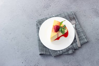 Japon pamuk cheesecake nane ve çilek beyaz bir plaka üzerinde bir parça. Kabuk peynirli kek. Gri taş veya beton arka plan. Seçici odak, kopya alanı. 
