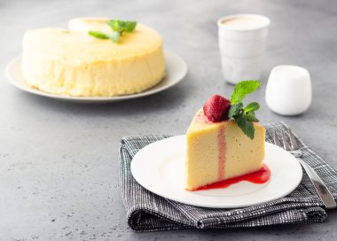 Japon pamuk cheesecake nane ve çilek beyaz bir plaka üzerinde bir parça. Kabuk peynirli kek. Gri taş veya beton arka plan. Seçici odak, kopya alanı. 