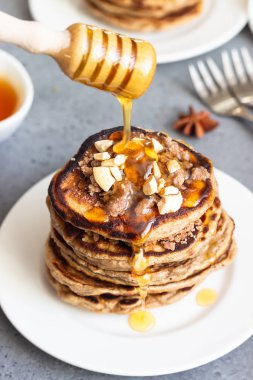 Kaju fıstığı, bal, tarçın ve beyaz bir tabakta anason ile Krep. Mükemmel kahvaltı. Gri beton arka plan. Kopyalama alanı.