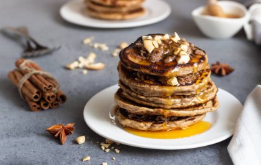 Kaju fıstığı, bal, tarçın ve beyaz bir tabakta anason ile Krep. Mükemmel kahvaltı. Gri beton arka plan. Kopyalama alanı.