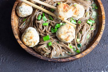 Soba erişte tavuk köfte ve yeşil soğan ile servis edilir. Karabuğday eriştesi. Glütensiz. Asya yemekleri. Kopyalama alanı.
