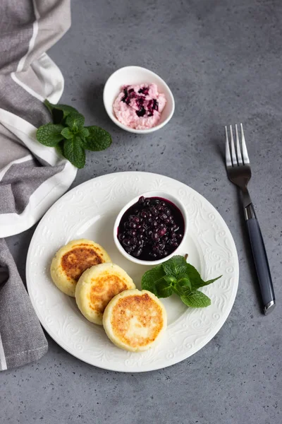 小屋奶酪煎饼或油条配蓝莓酱和薄荷 传统的乌克兰和俄罗斯美食 瑟尼基健康饮食早餐 — 图库照片
