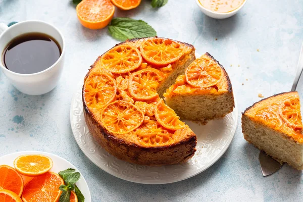 Upside down tangerine cake on a sky blue stone or concrete background.