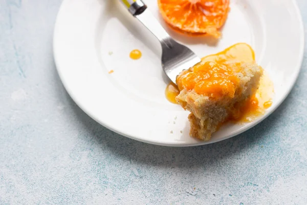 Upside down tangerine cake on a sky blue stone or concrete background.