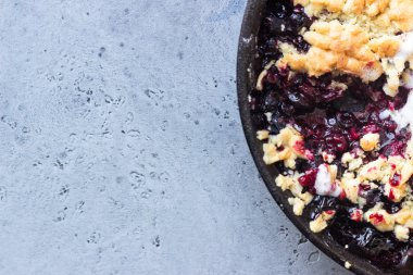 Siyah frenk üzümü kek dökme demir tavada vanilyalı dondurma ile. Sağlıklı gıda kavramı. Gri taş arka plan. Üstten görünüm. Kopya alanı.