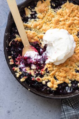 Siyah frenk üzümü kek dökme demir tavada vanilyalı dondurma ile. Sağlıklı gıda kavramı. Gri taş arka plan. Üstten görünüm. Kopya alanı.