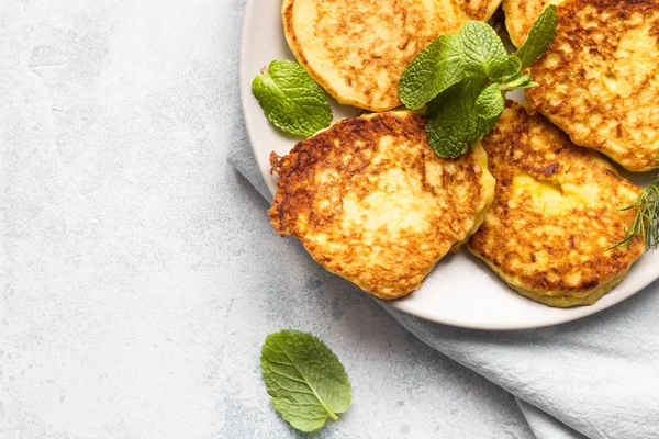 Zucchini fritters served with fresh herbs and yogurt dressing. Vegetarian zucchini pancakes. Copy space.