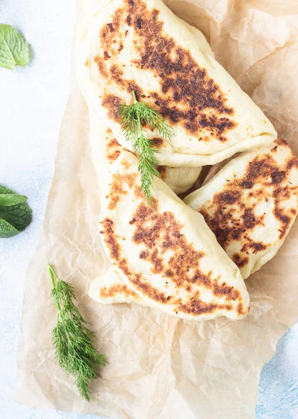 Frying pan baked flat bread with fresh herbs and yogurt dressing. Khychiny or qutab - traditional caucasian or Azerbaijani flatbread.