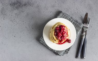 Vişne sos ve çikolata beyaz tabakta ile krep yığını. Gri beton arka plan. Uzay kopyalayın. Kahvaltı.