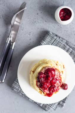Vişne sos ve çikolata beyaz tabakta ile krep yığını. Gri beton arka plan. Uzay kopyalayın. Kahvaltı.