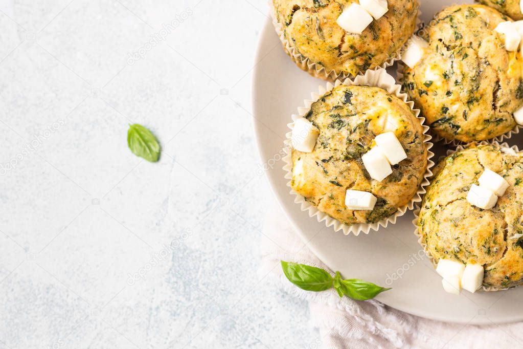 Freshly baked muffins with spinach and feta cheese. Light background. Copy space.