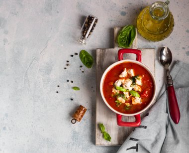 Tavuk, sebze ve fesleğen ile sıcak domates çorbası. Hafif beton arka plan. Uzay kopyalayın. Üstten görünüm. 