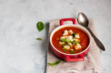 Tavuk, sebze ve fesleğen ile sıcak domates çorbası. Hafif beton arka plan. Uzay kopyalayın. Üstten görünüm. 